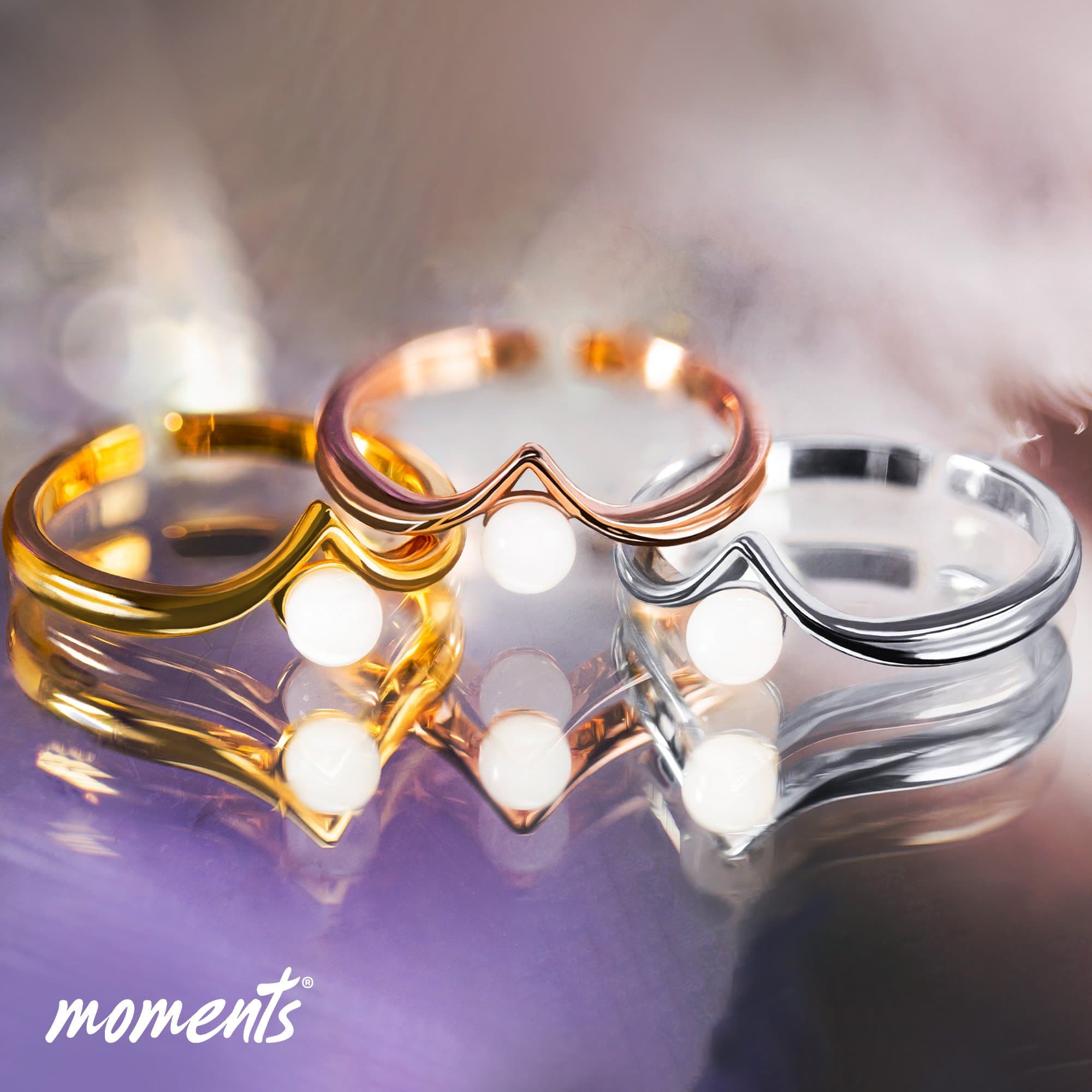 Ringe aus Gold, Roségold und Silber mit einer V-förmigen Vorderseite und einer weißen Perle.