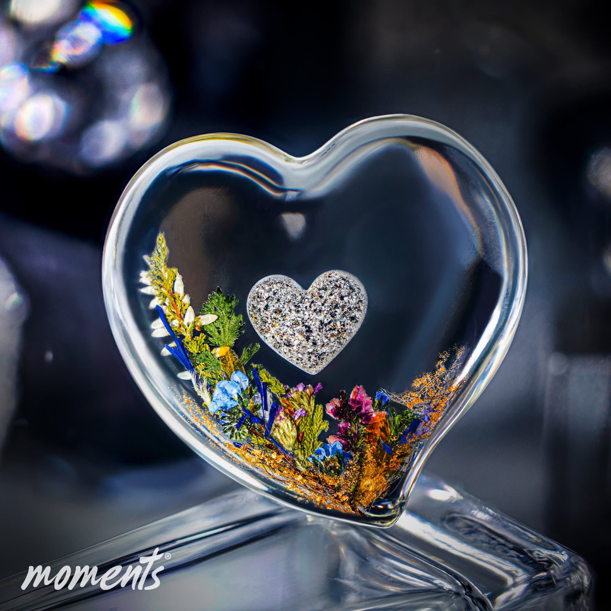 Klares herzförmiges Glas-Andenken mit getrockneten Blumen, Goldflocken und einem kleinen, strukturierten Herz.