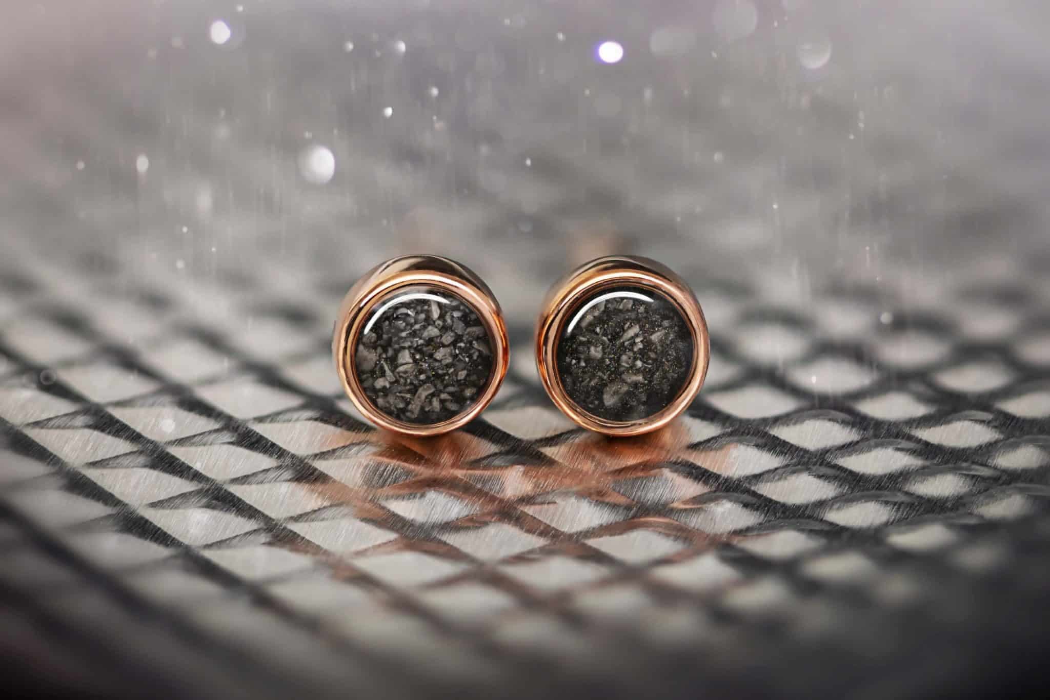Roségoldfarbene Ohrstecker mit dunkler, gesprenkelter Einlage.