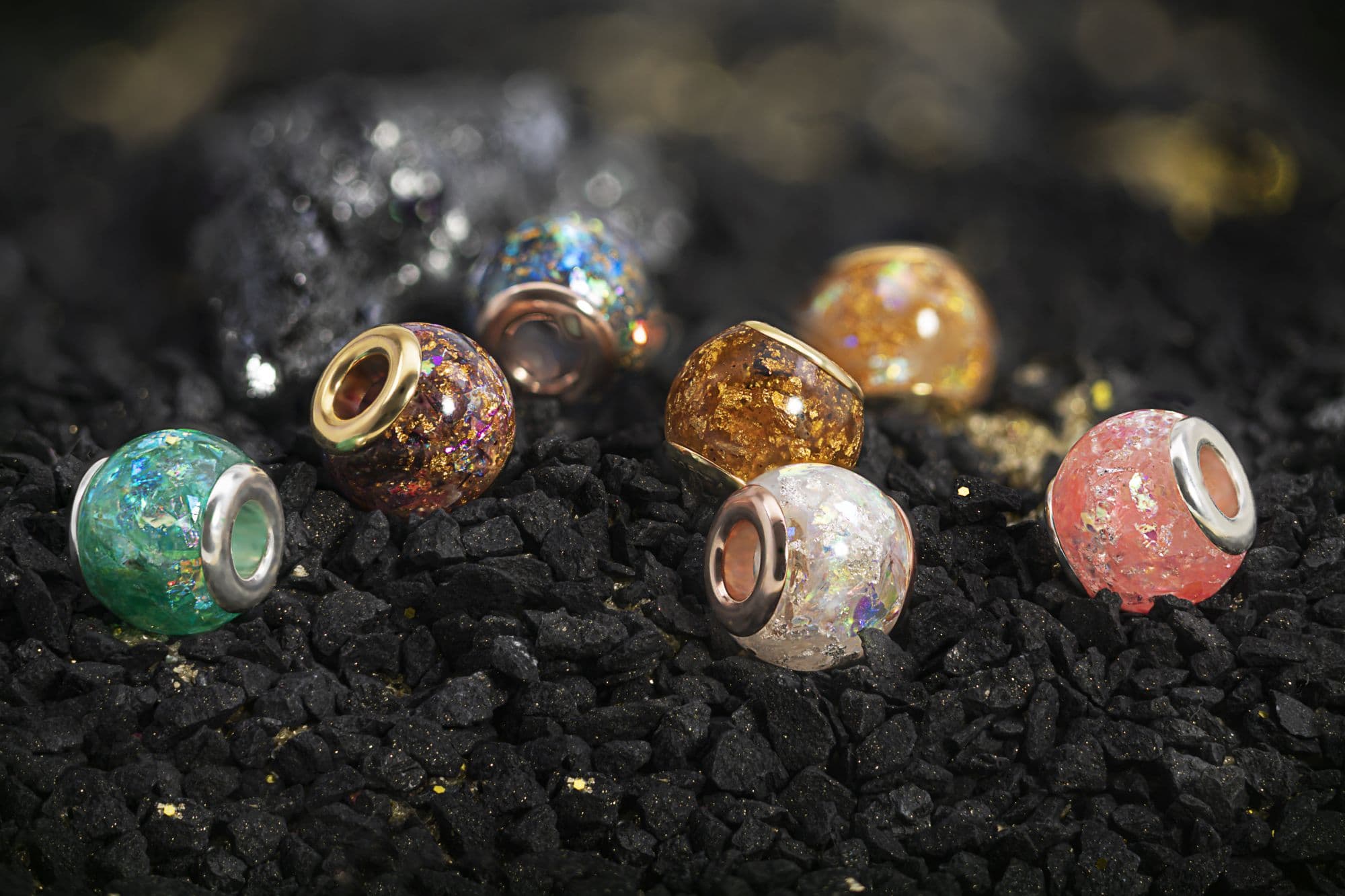 Verschiedene Glasperlen mit metallischen Sprenkeln und silber- oder goldfarbenen Kernen.