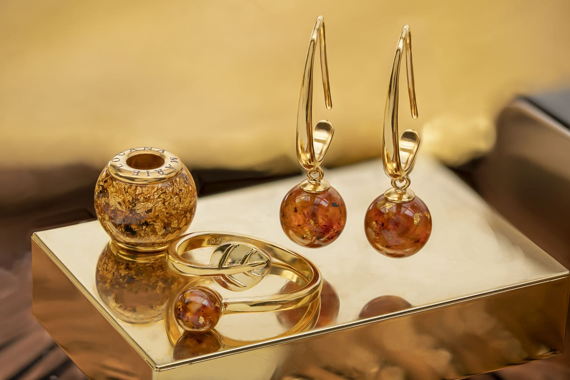 Goldfarbenes Schmuckset mit bernsteinfarbenen Perlen, die Goldflocken enthalten.