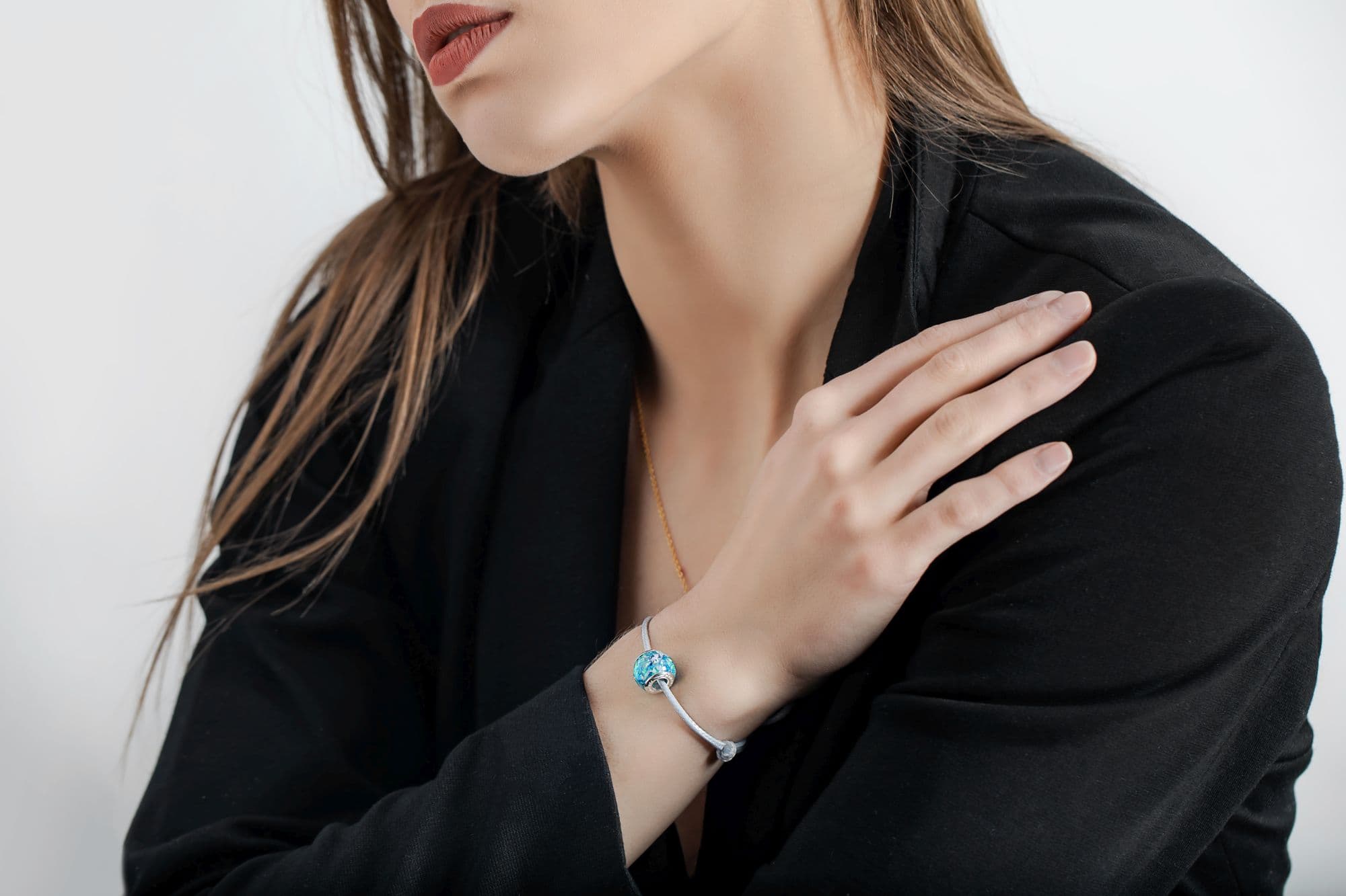 Silberarmband mit einer blauen Glasperle, die weiße Wirbel enthält.