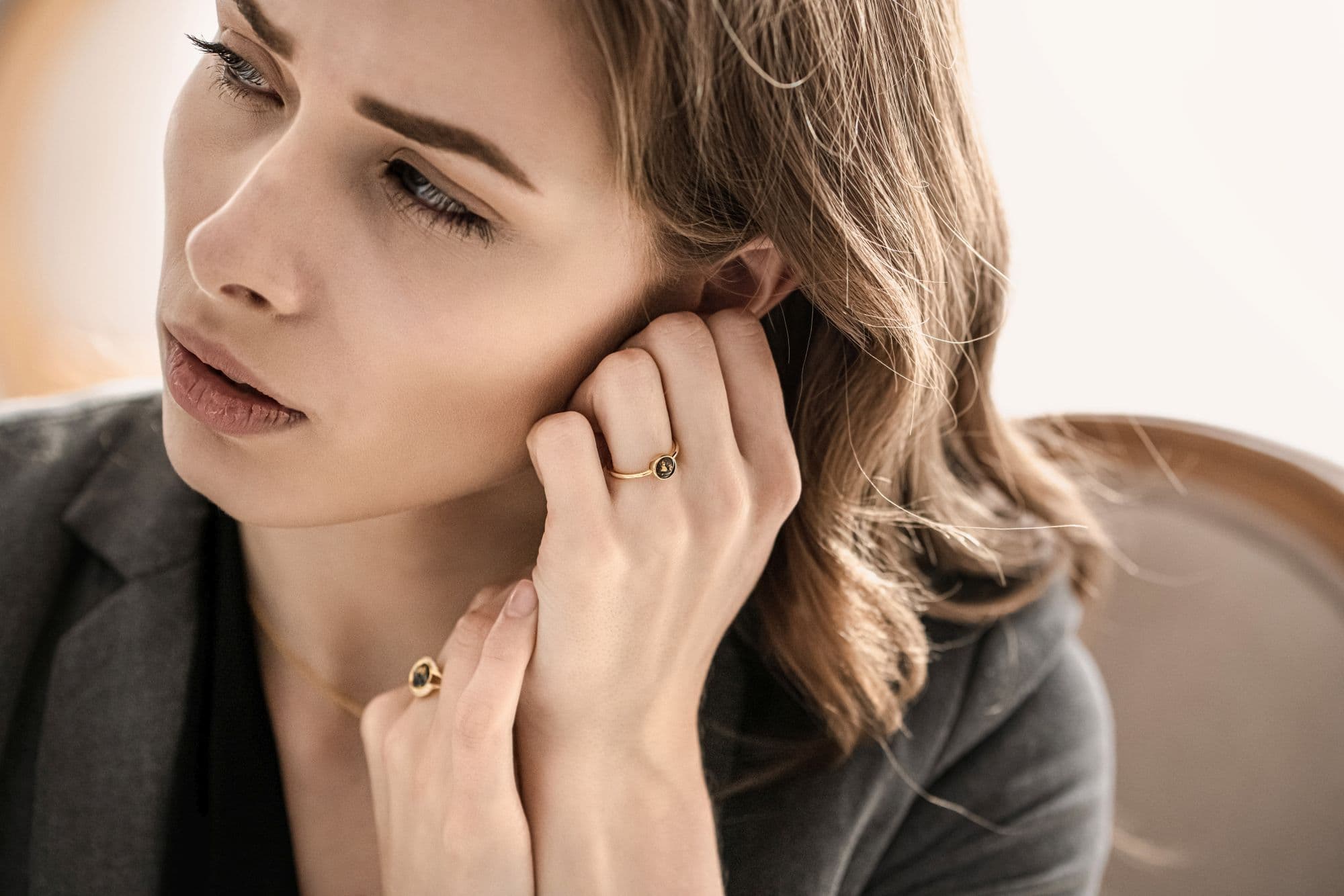 Goldring mit einem dunklen, runden Stein und einer goldenen Umrandung.