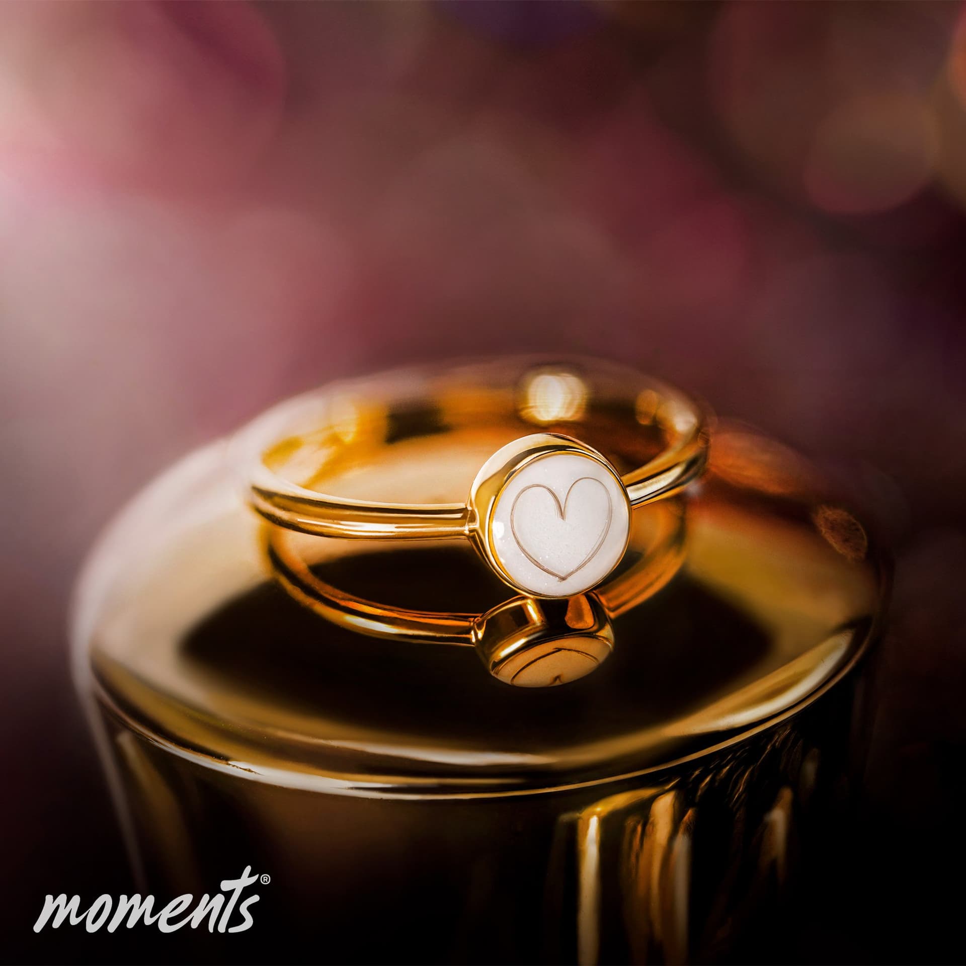 Gouden ring met een witte, ronde inleg met een subtiele hartomtrek.