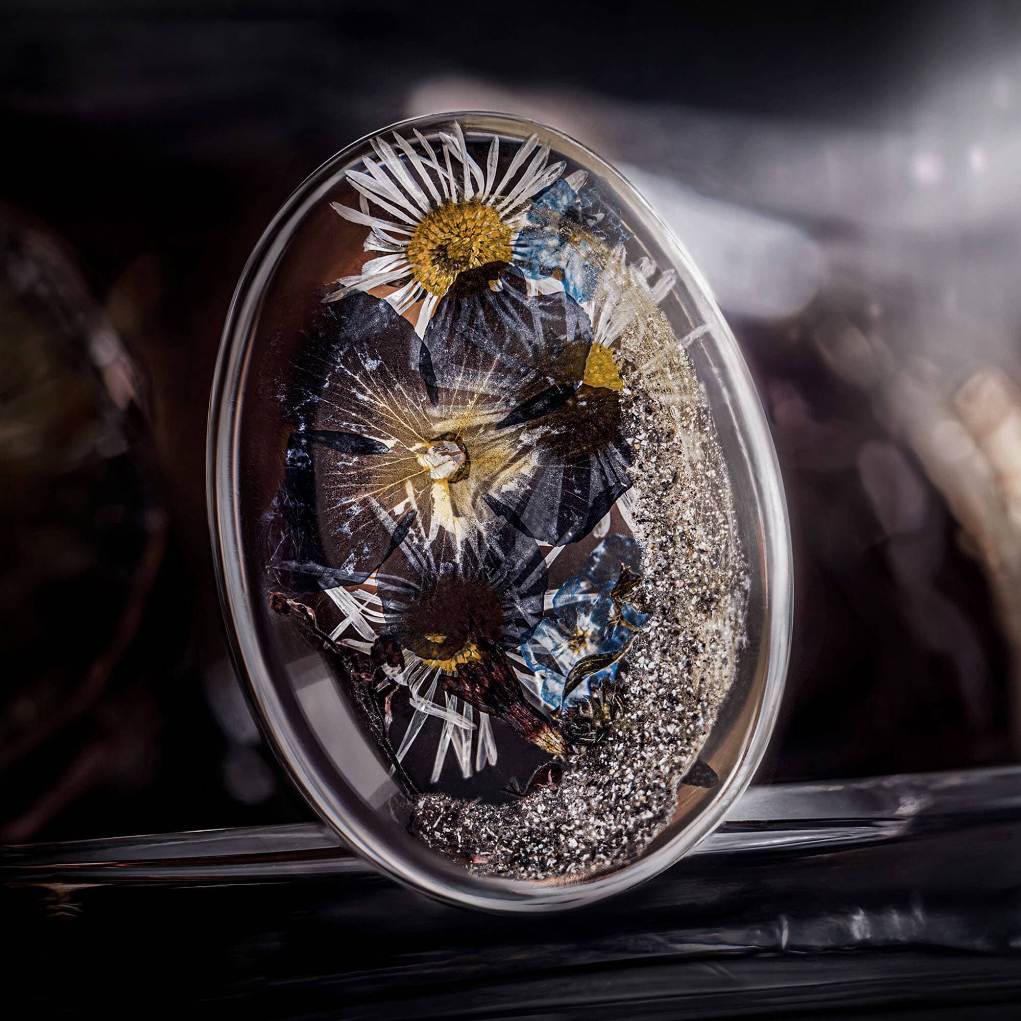 Ovaler Gedenkstein aus klarem Harz mit getrockneten Blumen und silbernem Glitzer.